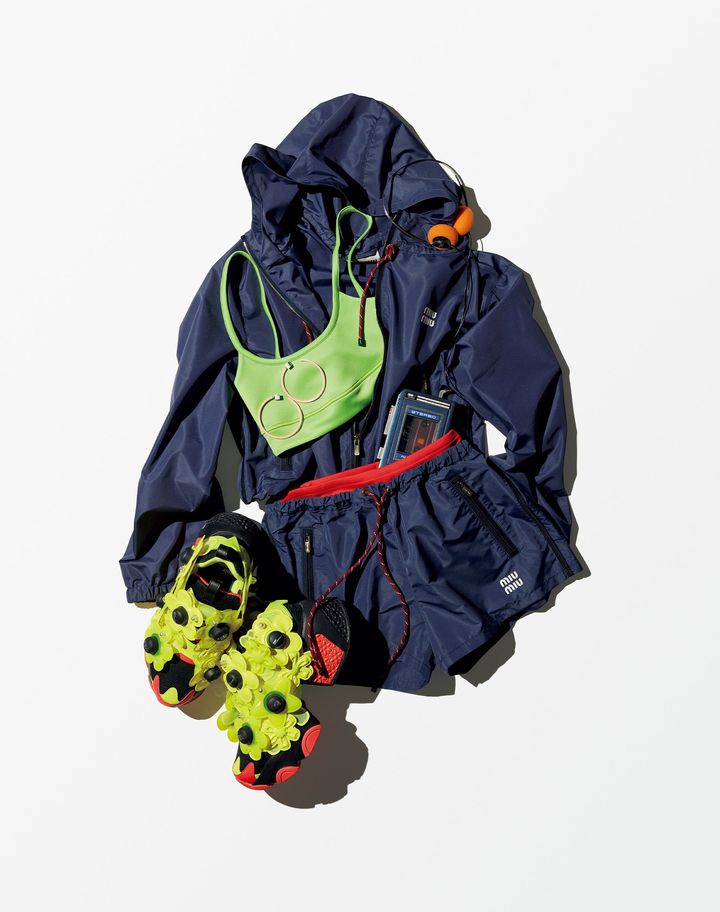 ナイロン素材のジップパーカ ￥379,500 赤のスイムウェア ￥114,400 ナイロン素材のショートパンツ ￥192,500（すべて予定価格）／MIU MIU（ミュウミュウ クライアントサービス） スポーツブラ ￥34,100／LONGCHAMP（ロンシャン・ジャパン） スニーカー ヒール約7.5㎝ ￥61,600／NOIR KEI NINOMIYA×REEBOK（コム デ ギャルソン） ピンクのフープピアス ￥13,200／BIJOU R.I（ビジュー アール・アイ）