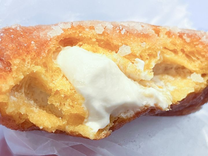 手に持った揚げドーナツ「マスカルポーネ生クリーム」