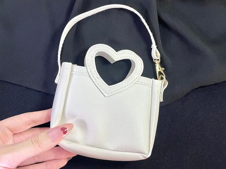 ダイソー「ハートバッグチャームポーチ」を手に持ち、裏側を紹介する画像