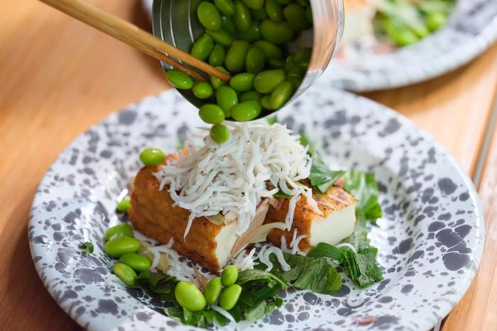 焼いた厚揚げにトッピングをかけている様子