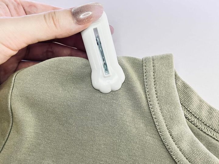 ダイソーの「スタンプ洗濯クリップ＜肉球柄＞」を手に持ってTシャツに挟んでいる画像