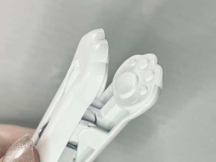 ダイソーの「スタンプ洗濯クリップ＜肉球柄＞」を手に持ち、猫の肉球型のスタンプ部分をアップで紹介する画像