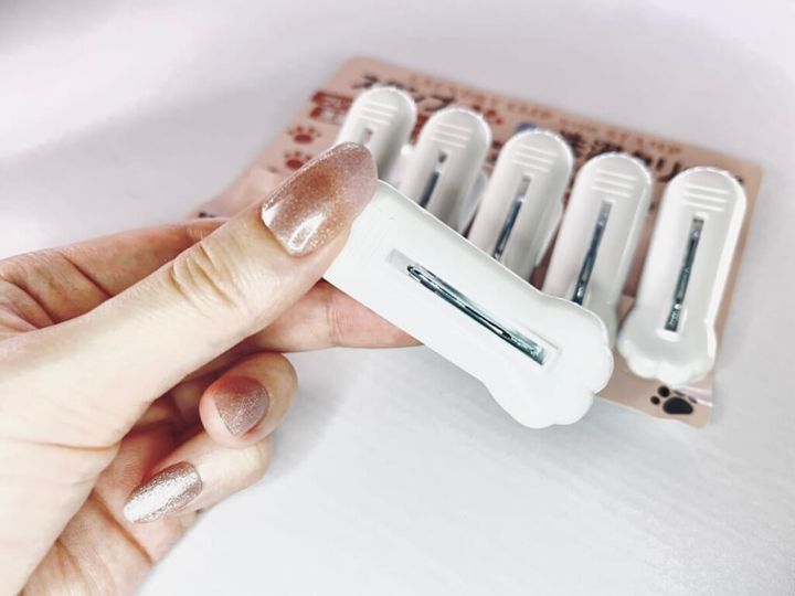 ダイソーの「スタンプ洗濯クリップ＜肉球柄＞」を手に持って紹介する画像