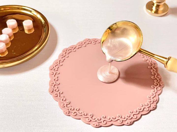 溶かした「シーリングワックス 粒タイプ」リッチピンクカラーを「シーリングスタンプ用 シリコーンマット」にたらしている画像