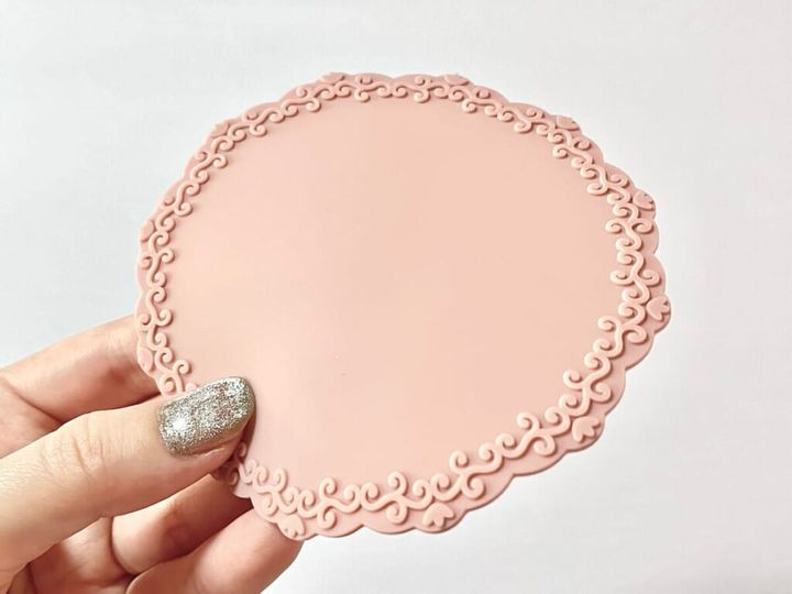 ダイソー「シーリングスタンプ用 シリコーンマット」を手に持って紹介する画像