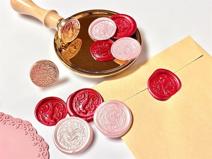 ダイソーのハンドメイド用品「シーリングスタンプ＆ワックス」でシーリングスタンプを作り、封筒にワックスをたらして封をした様子を紹介する画像