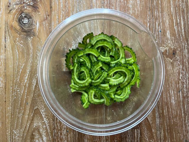 ゴーヤを5㎜の厚さにカットしてボウルに入れ、塩をまぶしてしばらくおく。
