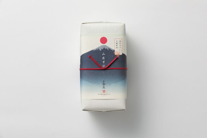 箱のデザインは旅人たちがおむすびを入れていた竹籠をイメージ。掛紙には、上から下へ徐々に色が薄くなっていく浮世絵の技法「一文字ぼかし」に、富士山と逆さ富士が描かれた力強くモダンなパッケージ。