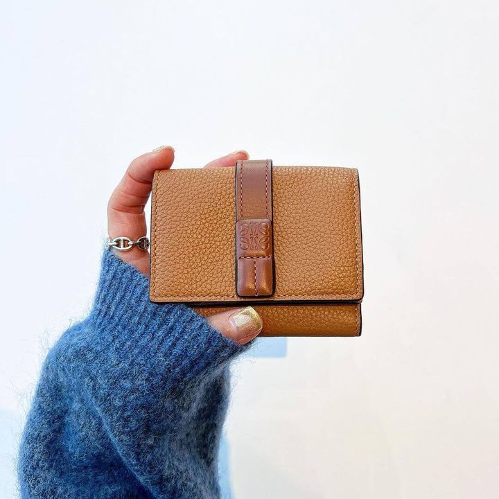 ロエベの三つ折り財布を持った女性