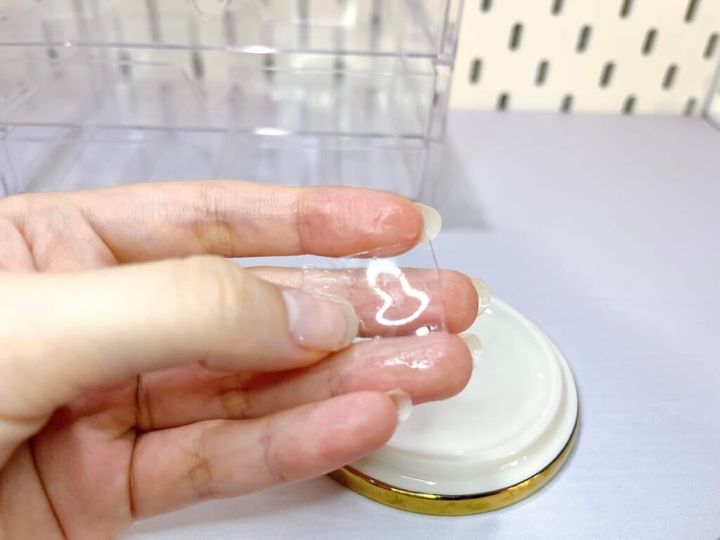 両面粘着ゲルテープ「KAERU GRIP（カエルグリップ）」を手に持ち、水洗いした様子