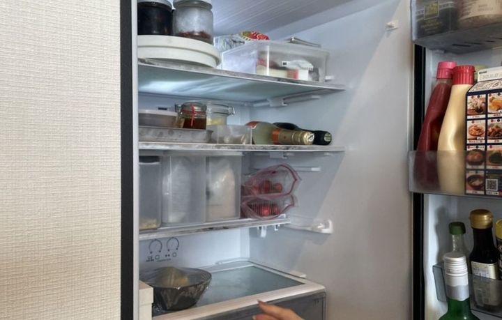 女性が冷蔵庫をあけて4段の内容が見えている写真