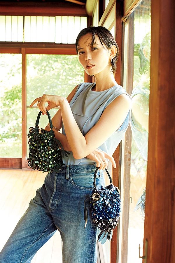 キラキラのスパンコールで彩られたカエルとサカナのバッグはハッピームードたっぷり。落ち着いた色とモダンな仕上がりで大人っぽくさらりと持てて、洒落感も気分もアップ。左手に持ったバッグ（カエル）［H 17×W16×D7］¥170,500、右手に持ったバッグ（サカナ）［H28×W 13×D4］¥170,500（ともにアニヤ・ハインドマーチ／アニヤ・ハインドマーチ ジャパン） トップス¥8,800（メゾンスペシャル／メゾンスペシャル 青山店） パンツ¥41,800（ハイク／ボウルズ） ピアス¥15, 400（ジュエッテ） リング（右手）¥19,800、アームカフ¥27,500（ともにエテ） リング（左手）¥22,000（エテ ビジュー）