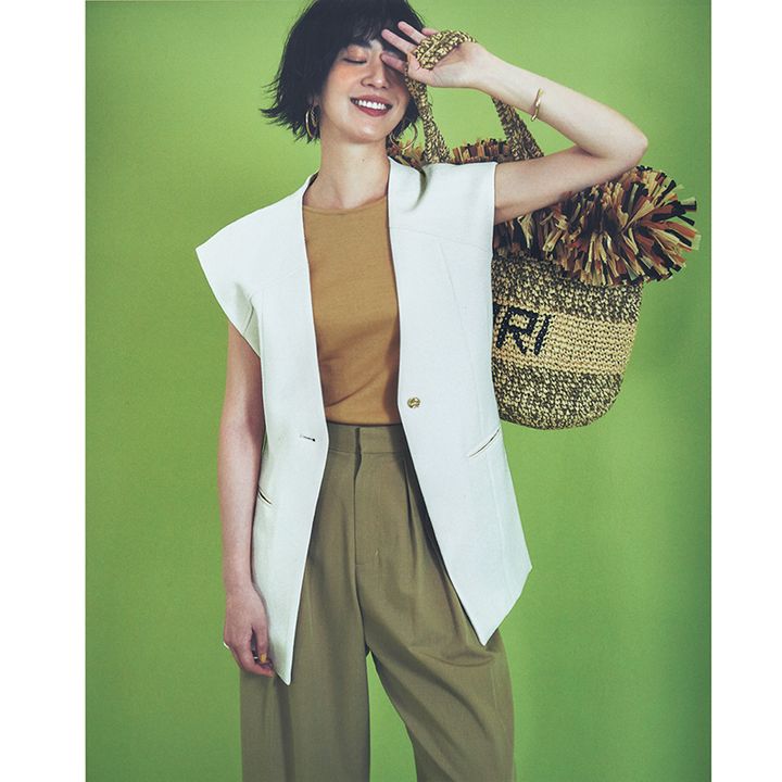 マスタードカラーのインナーに白ジレ、カーキのパンツのコーデ