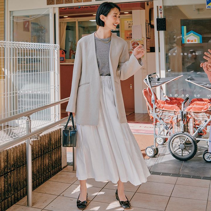 保育園を訪れる神山まりあさん。ジャケット・インナー・スカートをグレーのワントーンでまとめたコーデ。