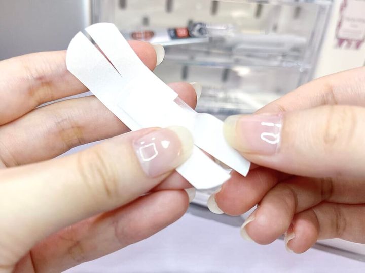 ドウジシャ「救急！！キズテープ」を手に持ち、ハサミで両側に切り込みを入れた様子