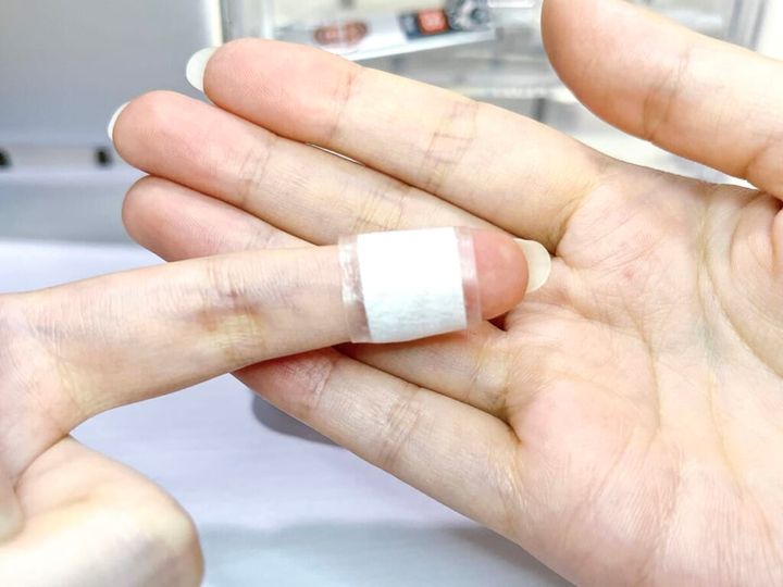 ドウジシャ「救急！！キズテープ」にハサミで切り込みを入れて、指先に貼って紹介する様子