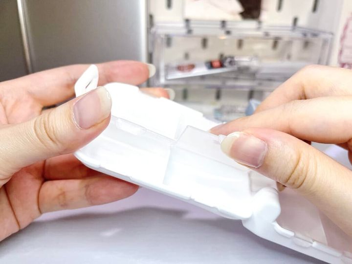 山田化学「リボロス 3段パーツケース」を手に持ち、ケースの蓋をあけて紹介する様子