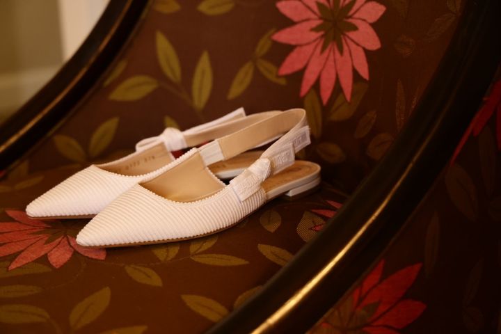 軽快なミディ丈ドレスに合わせたディオールのフラットシューズ
