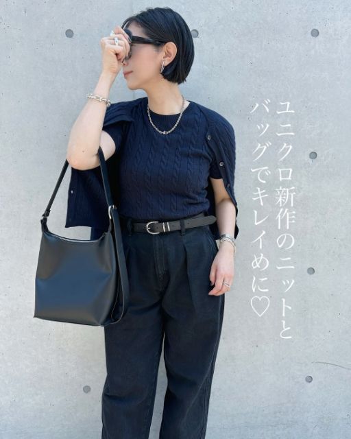 ネイビーのケーブルクルーネックカーディガンとケーブルクルーネックセーターを着用