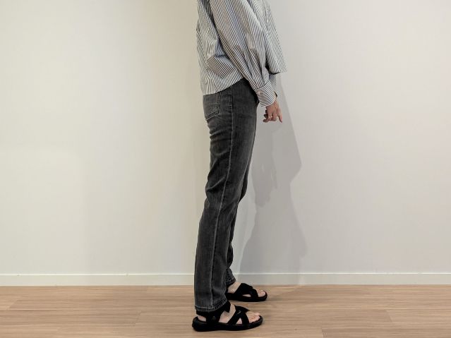 丈長めのスティックジーンズを着た横向き