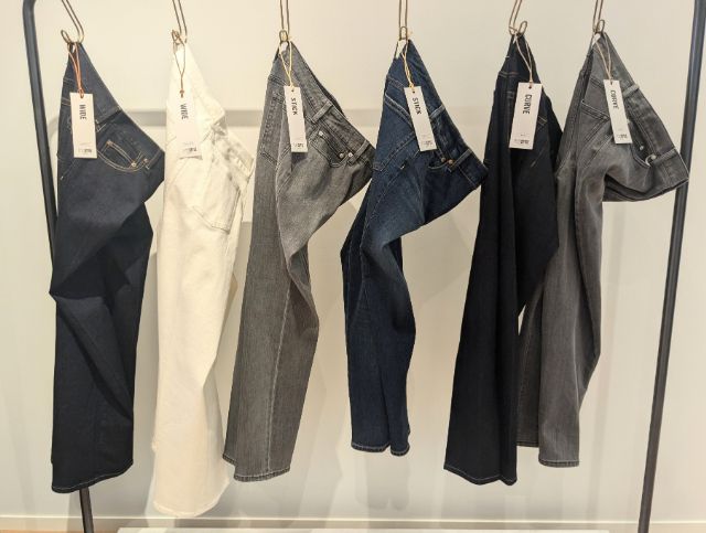 プラステのデニムがラックにかけられている
