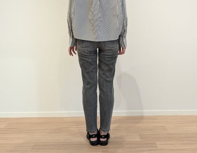 丈長めのスティックジーンズを着た後ろ側