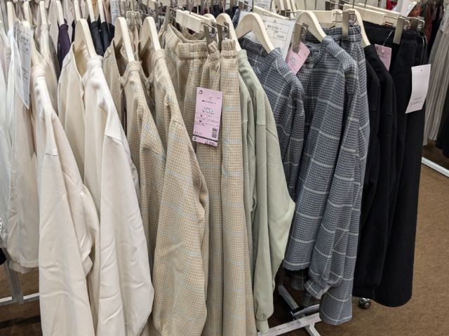 ラックにかけられた撥水バッグギャザーシャツと撥水フレアスカート