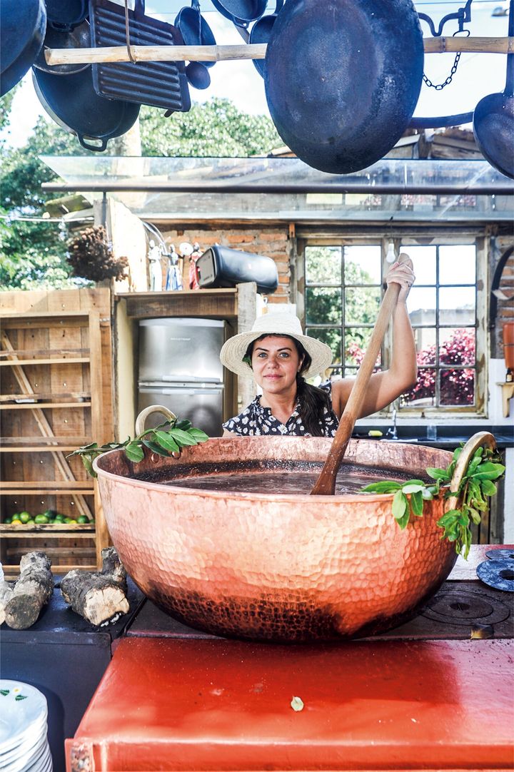 自身の代表料理でもあるフェイジョアーダの大鍋をかき混ぜるジャナイナ・トーレス。