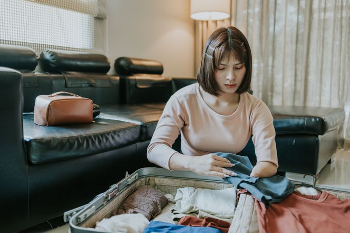 障害があるトランスジェンダーの女性が、旅行に向けて荷造りをしている