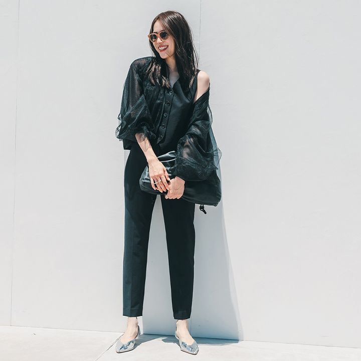 黒のジレとパンツに黒のチュールジャケットを重ねたコーデを着こなす笹川友里さん