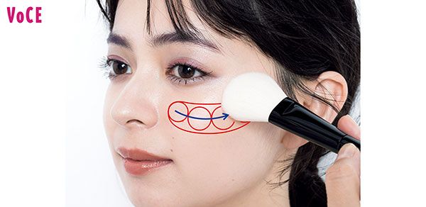 丸顔のチークの入れ方2. 顔の正面中央にチークをサッと入れ、少しカーブをつけながら横に広げ、目尻の下まで来たらブラシを引き抜くようにサイドへ向かってハネ上げる