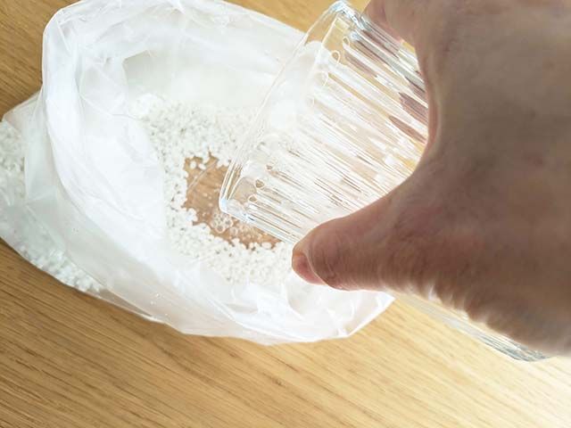 ポリ袋に入った無洗米に水を入れている様子