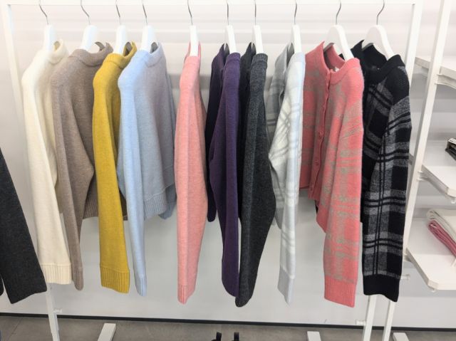 カラーもののカーディガンがラックにかけられている