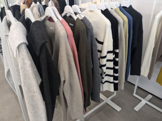 バリエーション豊富なニットがラックにかけてある