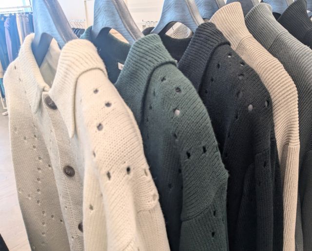 ラックにかけられた透かし編みニットポロカーディガン