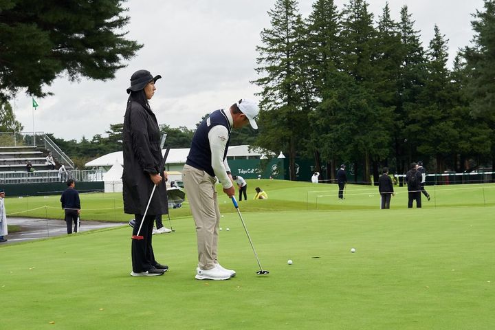 ゴルフをする人低い精度で自動的に生成された説明