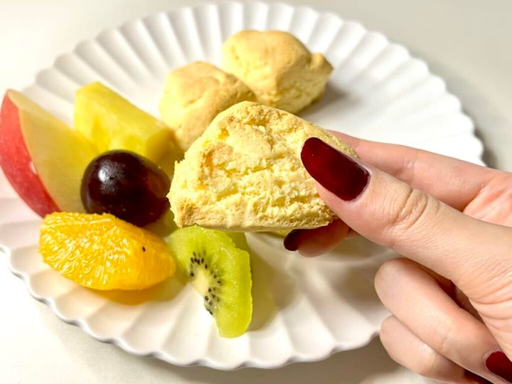 無印良品の「米粉のパンケーキ」を使った“スタバ風スコーン”を手に持ち、厚みを紹介する様子