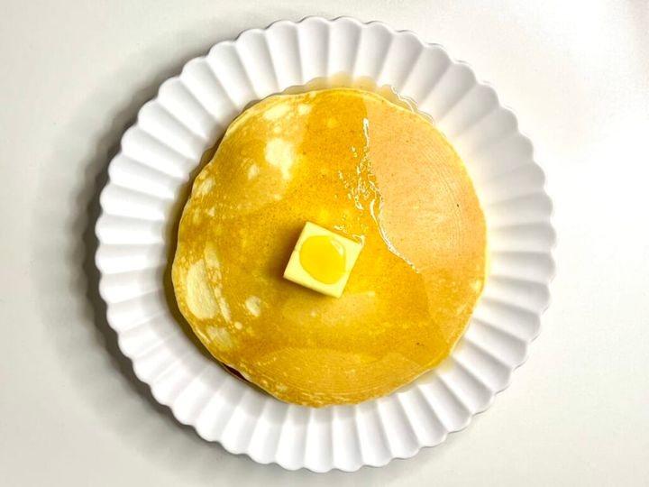 無印良品の「米粉のパンケーキ」を焼いて皿に盛りつけ、生地の上にバターとメープルシロップをかけて真上から撮影した画像