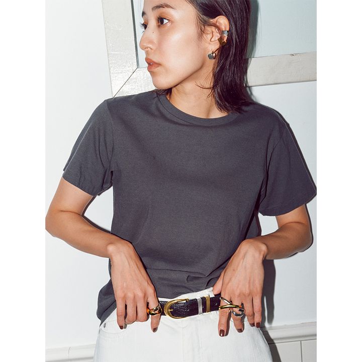 グレーの無地Tシャツに白デニムを黒ベルトで引き締めたコーディネート