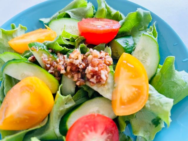 トマトときゅうり、レタスのサラダに万能香味えび油をかけた様子