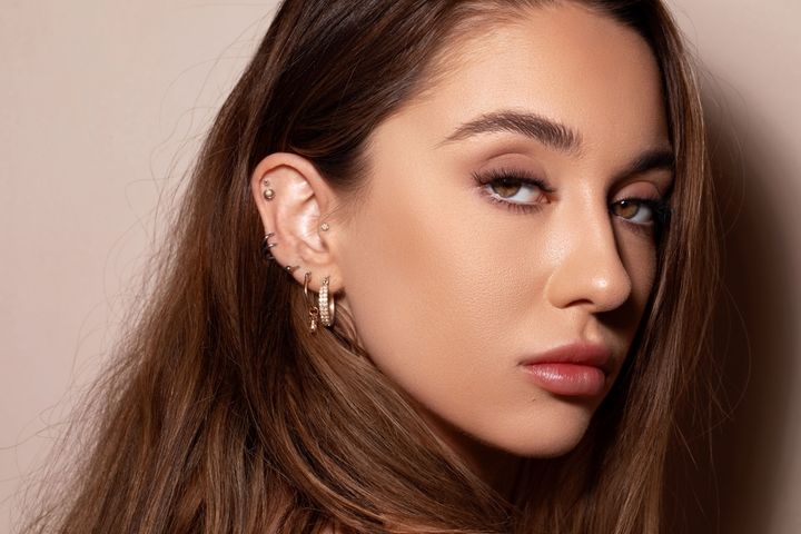 さまざまな位置にピアスを開けている女性