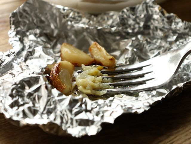 焼けたにんにくをフォークで潰す