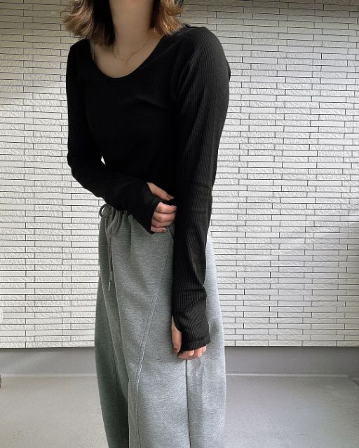 黒のストレッチリブUネックTを着ている