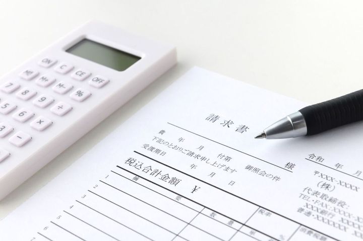 請求書とボールペンと電卓