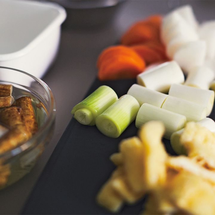 手順2の写真：出汁を煮ている間に野菜を切る。長ネギ、大根、にんじん、里芋、しめじ、こんにゃくをすべて1口サイズに