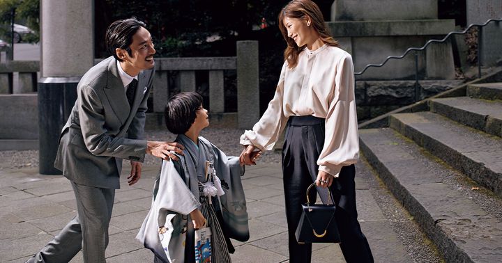 光沢のあるピンクベージュのブラウスと黒パンツに黒のフラットシューズとバッグを合わせた七五三コーデ