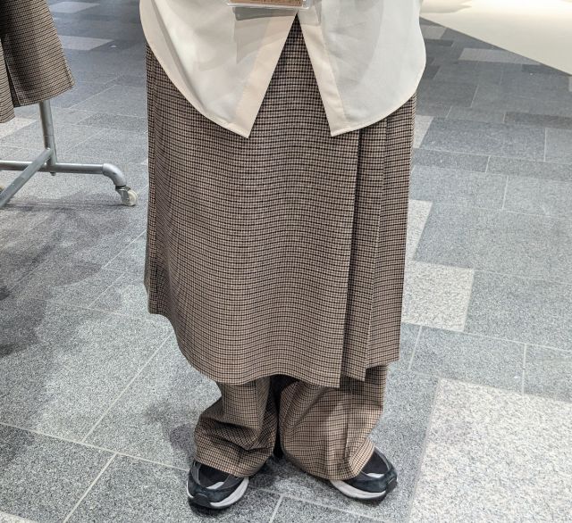 チェック柄の2ピーススカートパンツを穿いている