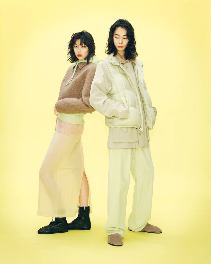 〈左〉ジャケット ￥85,800 緑のフーディ ￥33,000 下に着たニット ￥44,000 スカート ￥26,400 ブーツ ￥121,000 〈右〉ジャケット ￥121,000 ダウンベスト ￥79,200 中に着たピンクトップ ￥26,400 パンツ ￥41,800 スリッポン ￥68,200／すべてAURALEE（オーラリー）