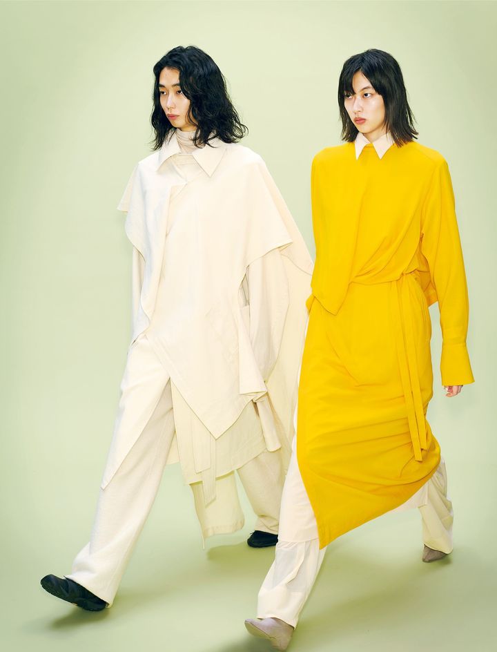 〈左〉カーディガン ￥132,000 コート ￥220,000 トップ ￥55,000 パンツ ￥99,000 シューズ 参考商品 〈右〉黄色のドレス ￥115,500 下に着た白のロングドレス ￥96,800 パンツ ￥82,500 ブーツ ￥73,700／すべてISSEY MIYAKE（イッセイ ミヤケ）