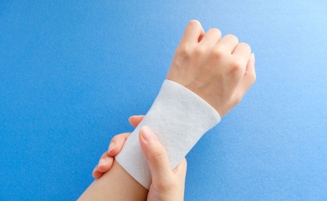 左手首に湿布を貼っているイメージ